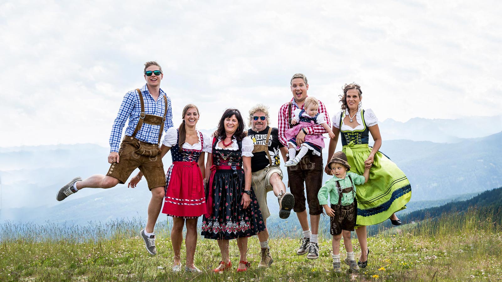 a family dressed in typical southtyrolean clothes on a hike near Hotel Alpenfrieden