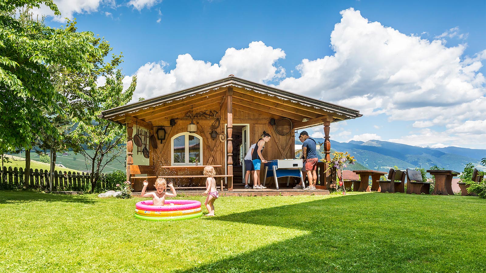 a wooden house in the garden of Hotel Alpenfrieden in summer