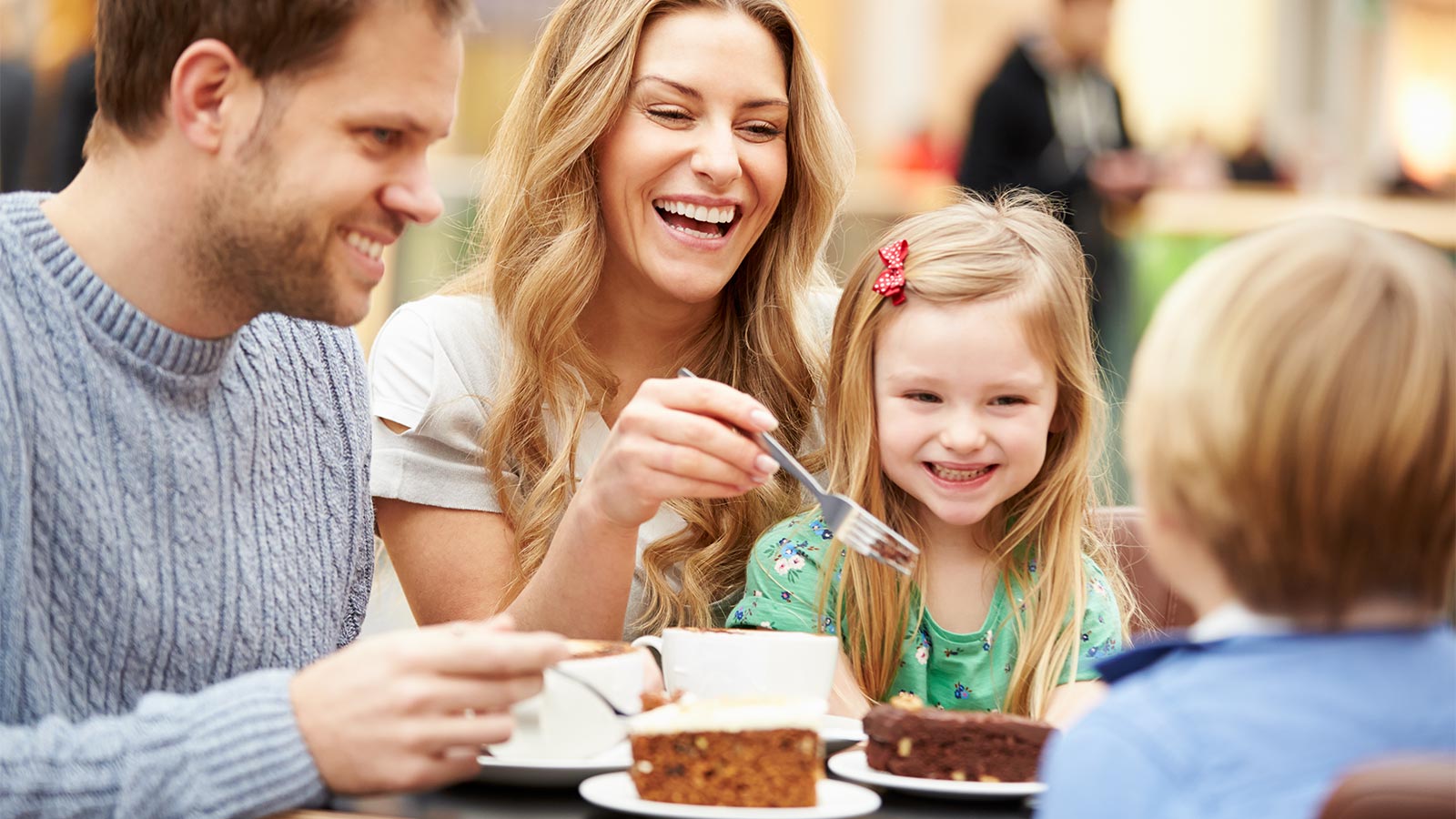 una famiglia mangia una torta e beve un caffè  