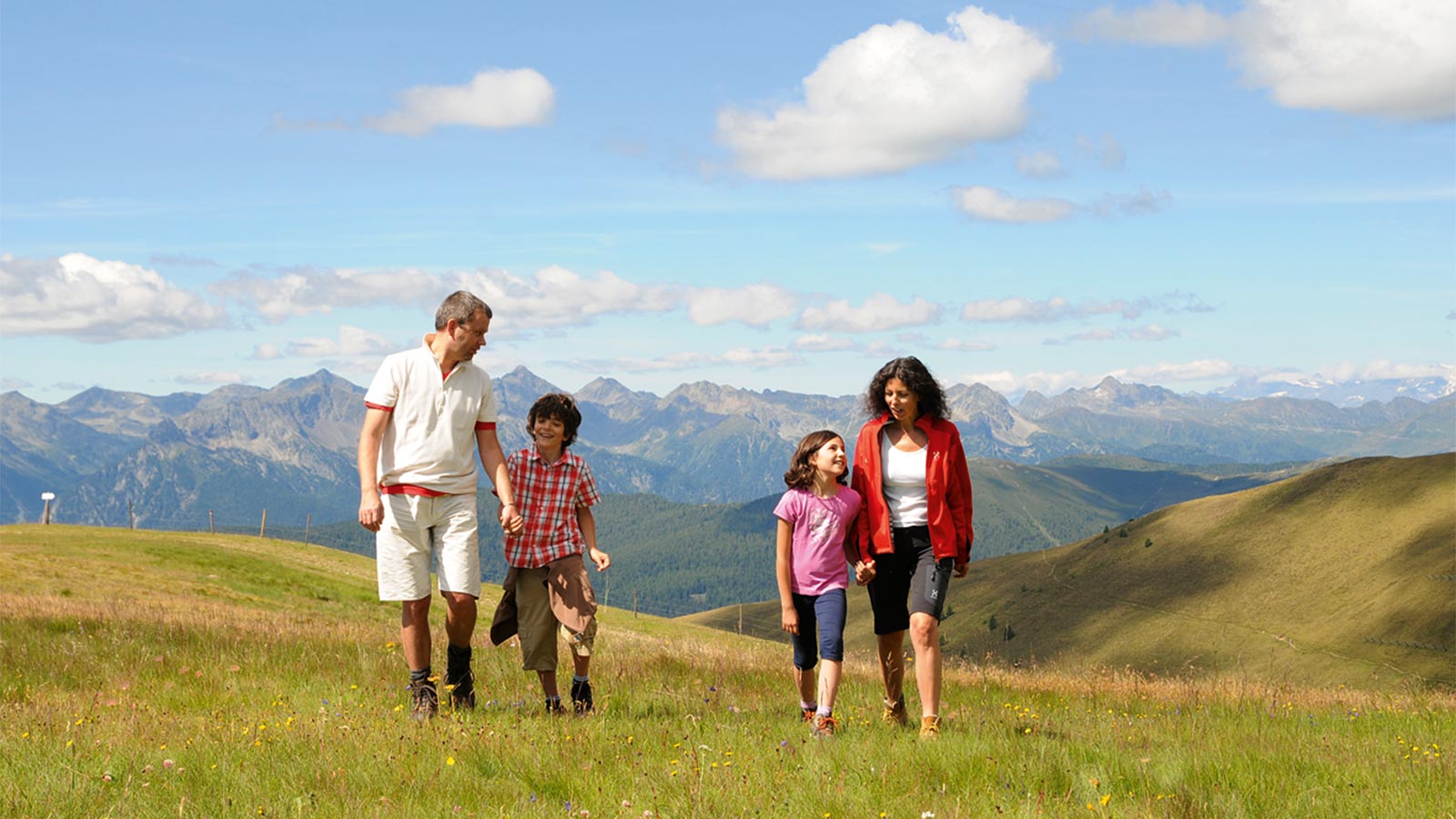 a family hiking on a meadow near Hotel Alpenfrieden
