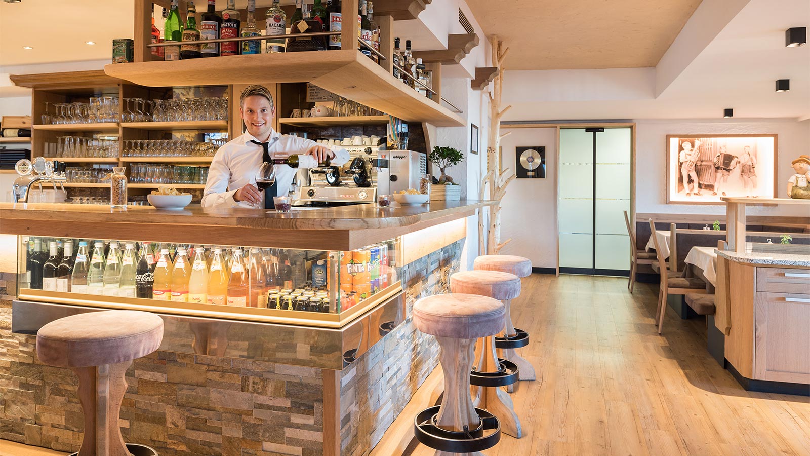 die Bar des Hotel Alpenfrieden in Meransen, der Barman ist bei der Arbeit