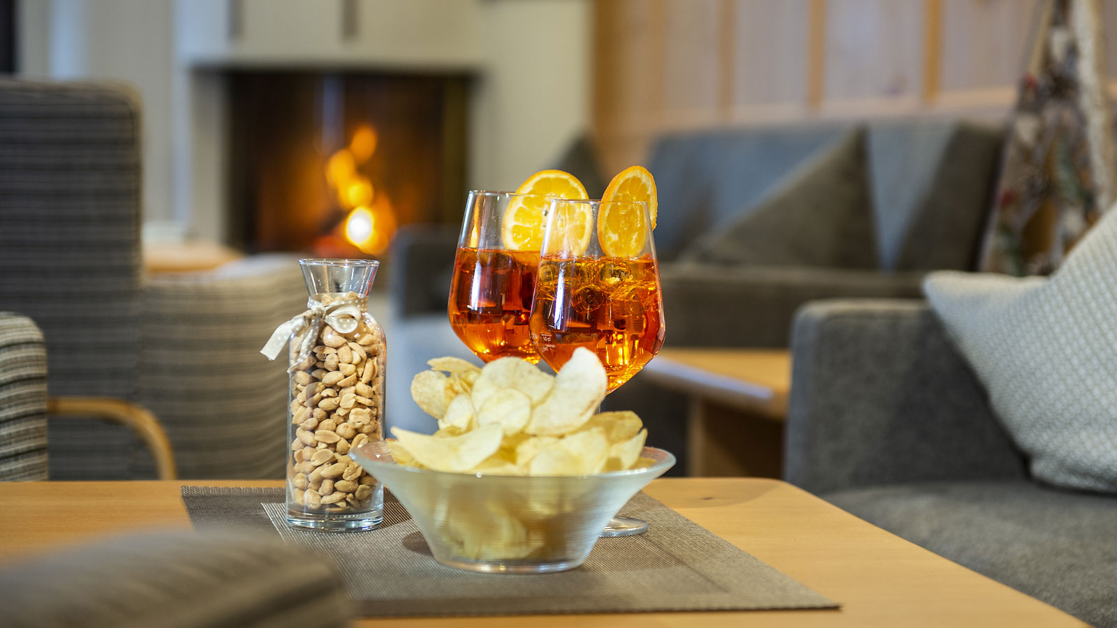 due aperitivi sul tavolino della lounge all'hotel Alpenfrieden accanto a dei snack - noccioline e patatine