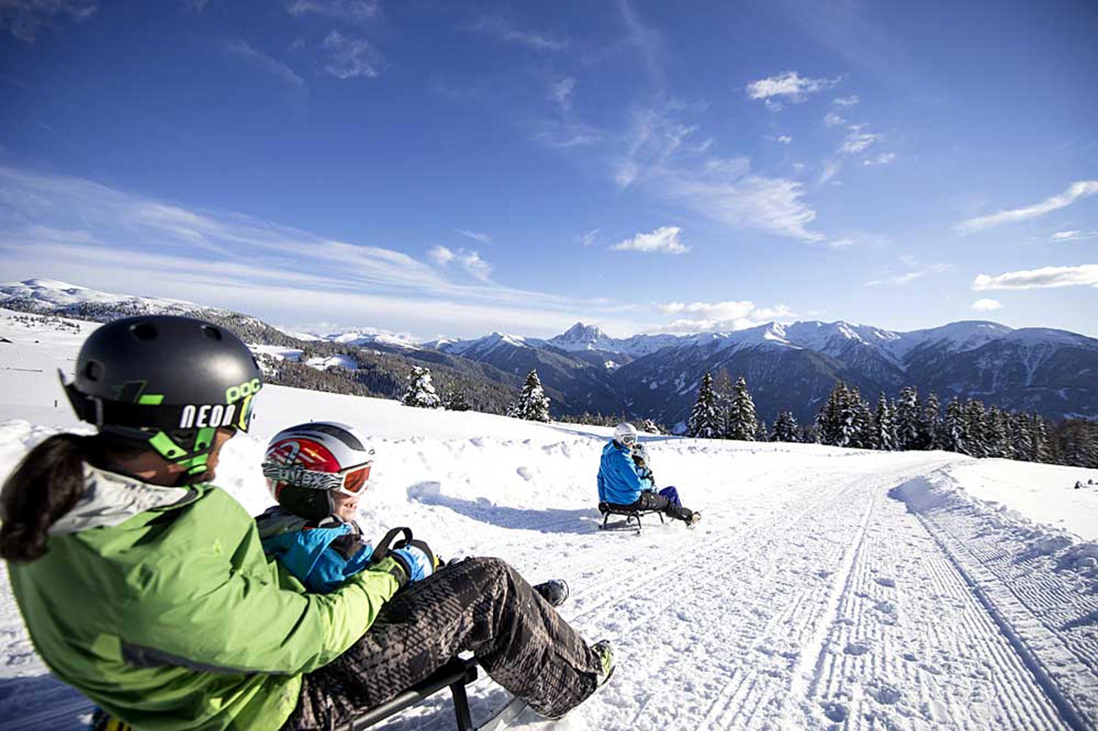 a family on the sledge is having fun on the slope