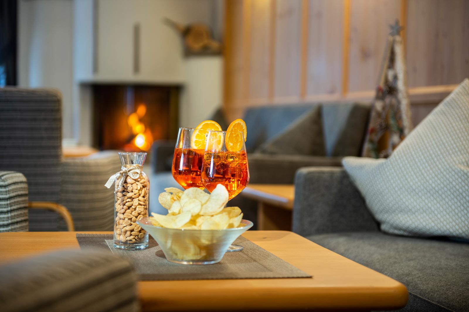 due aperitivi sul tavolino della lounge all'hotel Alpenfrieden accanto a dei snack - noccioline e patatine