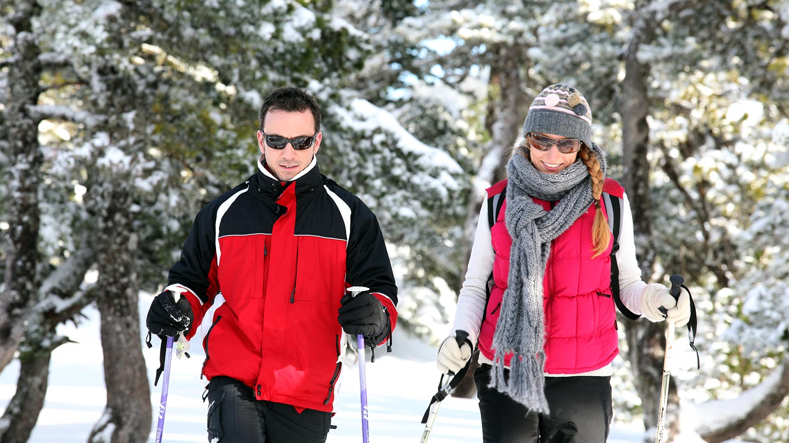 a couple is hiking in the snow near Hotel Alpenfrieden