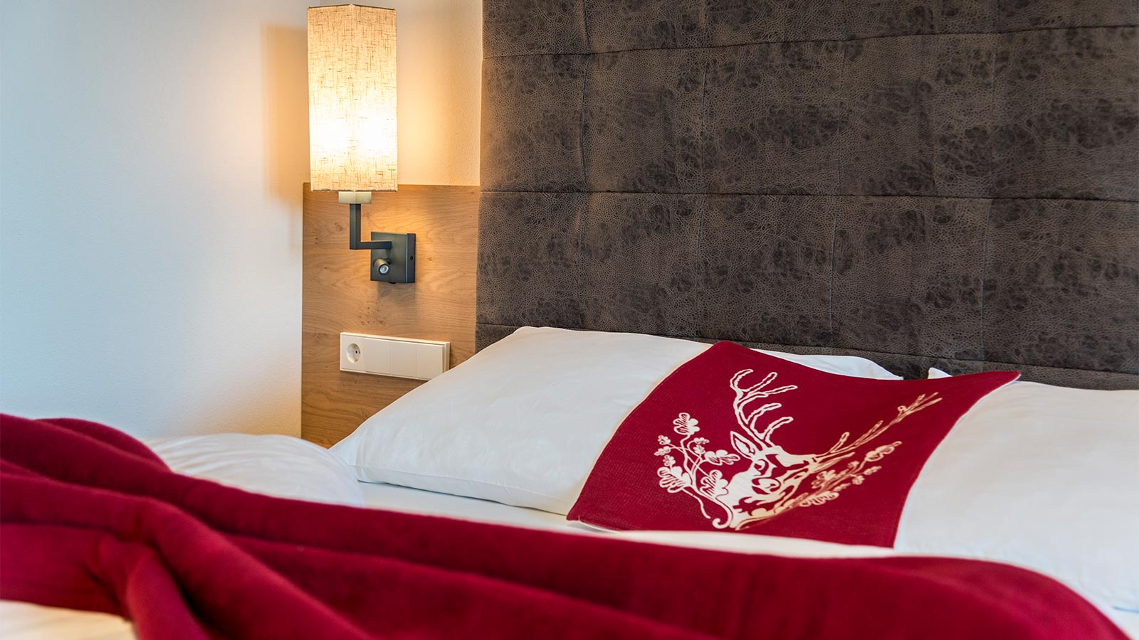 dettaglio del letto all'interno di una camera dell'hotel Alpenfrieden a Maranza